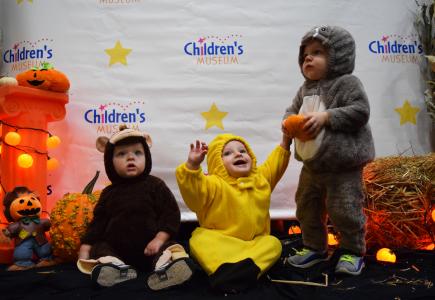 three children in halloween costumes