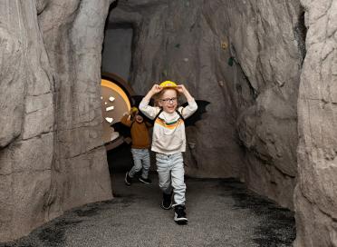 Child runs in cave exhibit