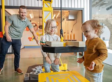 Two children play with toy blocks and toy crane